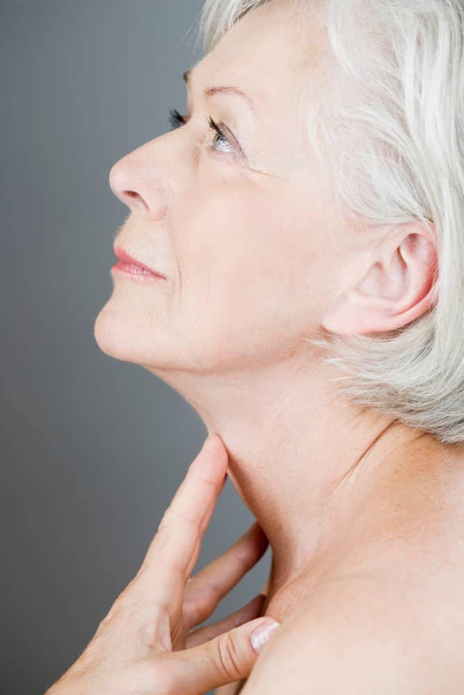 Mature woman's profile demonstrating ideal jawline and neck contours achieved through safe non-surgical enhancement with the 7-layer safety protocol
