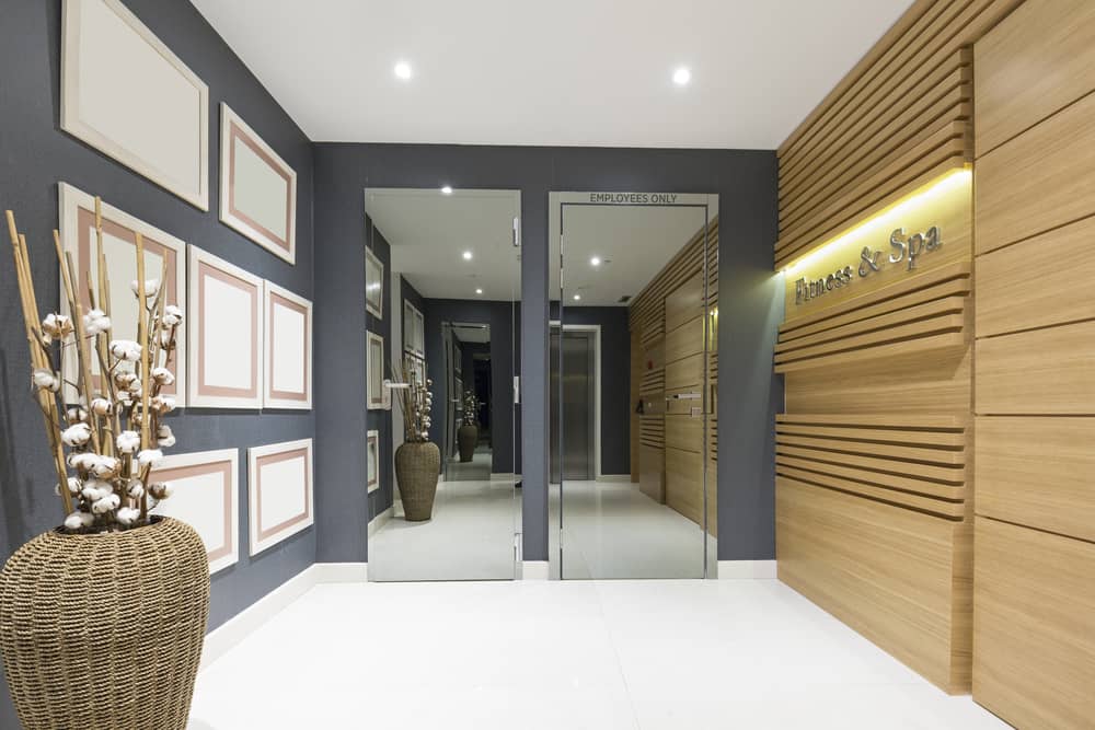 Modern med spa entrance with wood accent wall, dark gray walls, and professional lighting