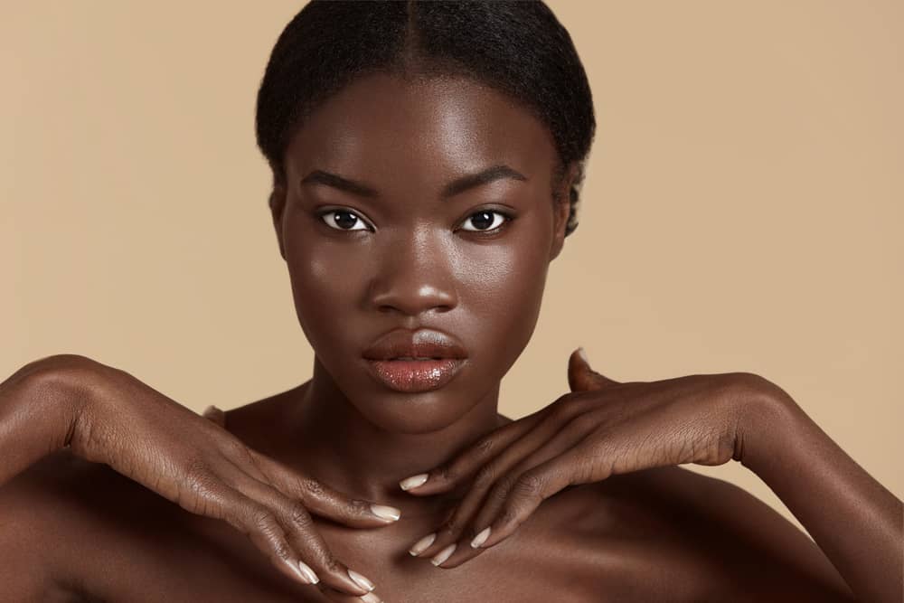 Black woman with smooth even-toned dark skin showing clear complexion after pulsed dye laser treatment for keloid reduction