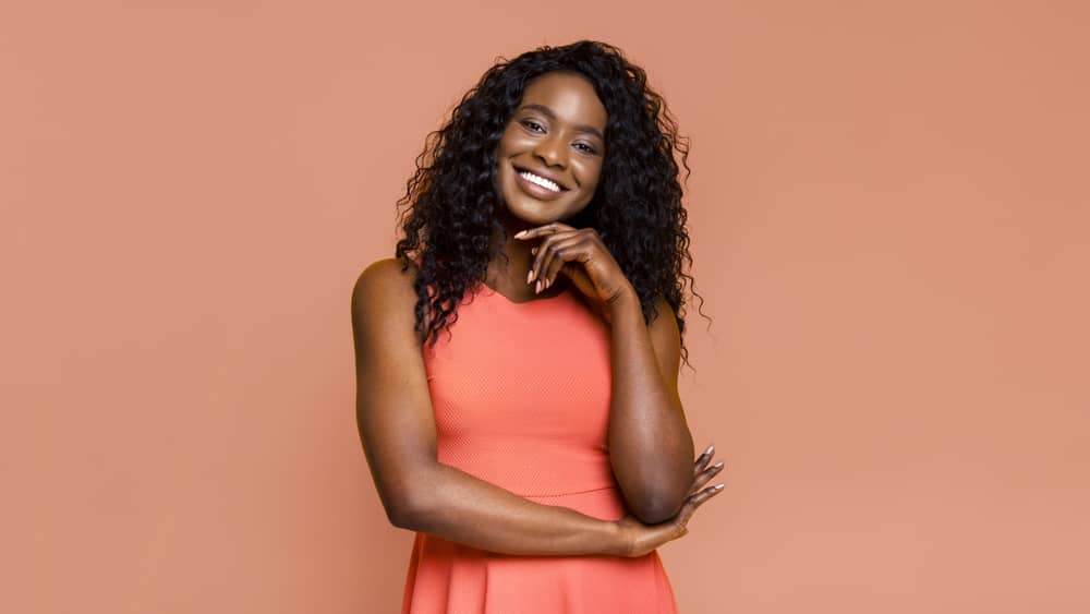  Smiling Black woman with healthy radiant skin and natural curls after safe aesthetic treatment