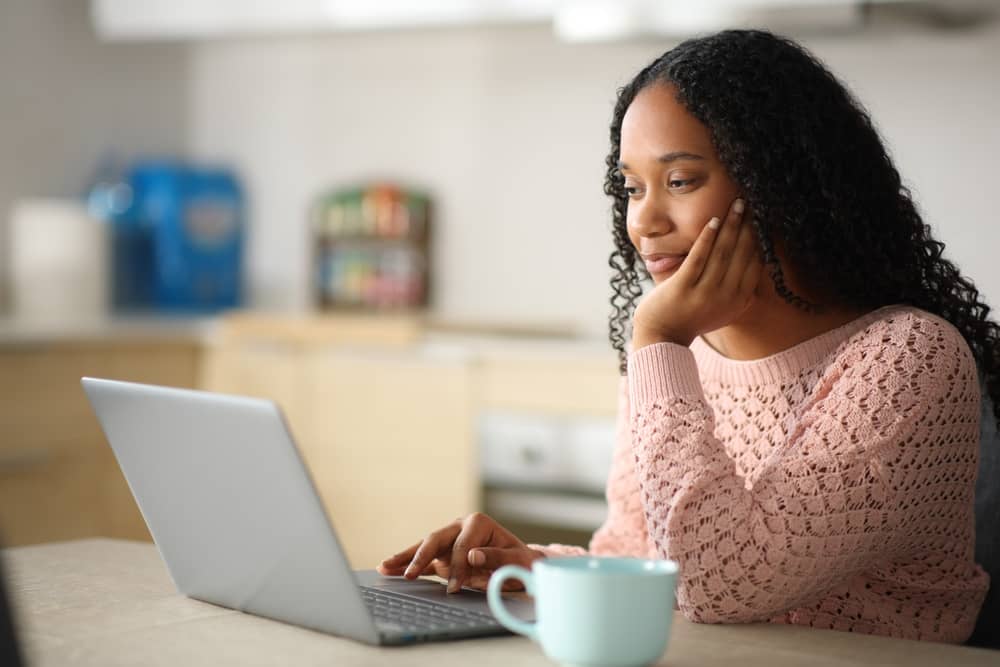 Black woman doing online research to find qualified provider for pigment-safe laser treatments